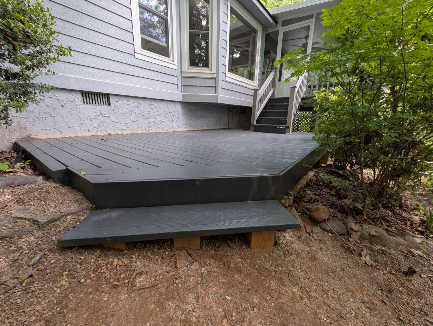 The same low deck rebuilt and finished in charcoal, with a clean step down to the ground.